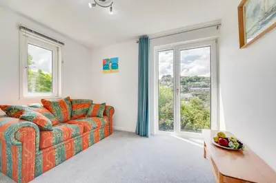a living room with a couch and large windows at 2 Bed in Looe oc-mizzen in Looe