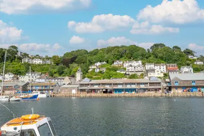 a boat in the water in front of a town at 2 Bed in Looe oc-mizzen in Looe