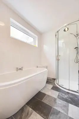 a white bathroom with a tub and a glass shower at 2 Bed in Looe oc-mizzen in Looe