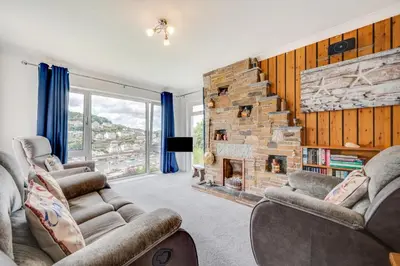 a living room with two couches and a stone fireplace at 2 Bed in Looe oc-mizzen in Looe