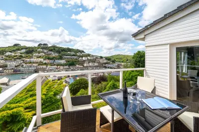 a balcony with a glass table and white chairs at 2 Bed in Looe oc-mizzen in Looe