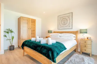 a bedroom with a bed with a green blanket at 3 Bed in Newquay oc-mordh in Newquay