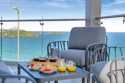 a table with a tray of food on a balcony with the ocean at 3 Bed in Newquay oc-mordh in Newquay