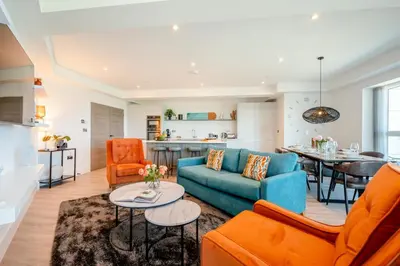 a living room with a blue couch and orange chairs at 3 Bed in Newquay oc-mordh in Newquay