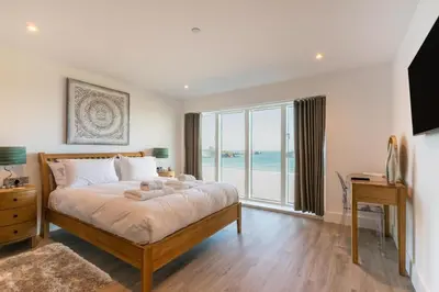 a bedroom with a large bed with a view of the ocean at 3 Bed in Newquay oc-mordh in Newquay
