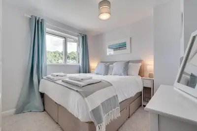 a bedroom with a large bed and a window at 2 Bed in Looe oc-msweet in Looe