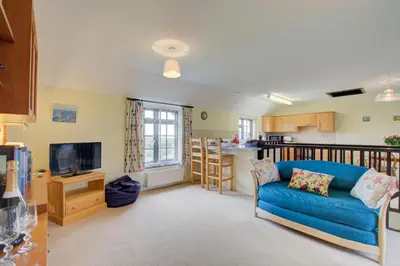 a living room with a blue couch and a kitchen at 2 Bed in Padstow oc-p00002 in Padstow