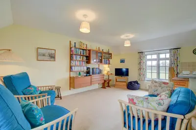 a living room with two blue chairs and a tv at 2 Bed in Padstow oc-p00002 in Padstow