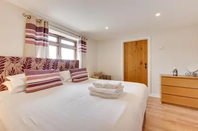a bedroom with a large white bed with towels on it at 1 Bed in St. Merryn oc-nel42 in St Merryn