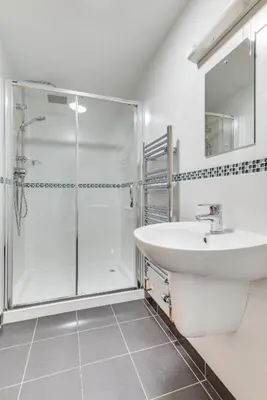 a white bathroom with a shower and a sink at 1 Bed in St. Merryn oc-nel42 in St Merryn