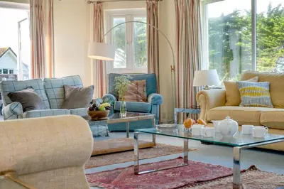 a living room with couches and a glass table at 6 Bed in Padstow oc-p00006 in St Merryn