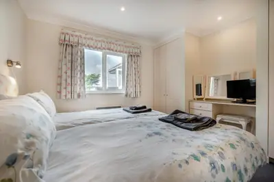 a bedroom with a large bed and a television at 6 Bed in Padstow oc-p00006 in St Merryn