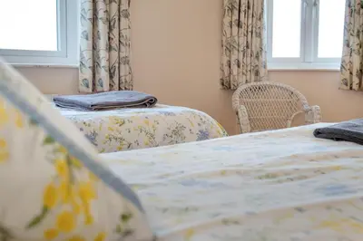 a bedroom with two beds and two windows at 6 Bed in Padstow oc-p00006 in St Merryn