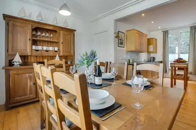 a kitchen and dining room with a wooden table and chairs at 4 Bed in Fowey oc-nend in Fowey