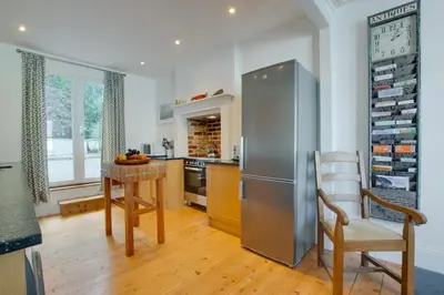 a kitchen with a stainless steel refrigerator and a table at 4 Bed in Fowey oc-nend in Fowey