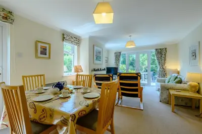 a dining room and living room with a table and chairs at 5 Bed in Padstow oc-p00053 in St Merryn