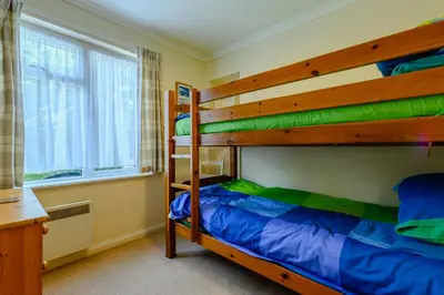 a bedroom with two bunk beds and a window at 5 Bed in Padstow oc-p00053 in St Merryn