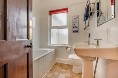 a bathroom with a sink and a toilet and a window at 3 Bed in Padstow oc-p00043 in St Merryn
