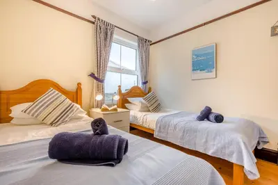 a bedroom with two beds and a window at 3 Bed in Padstow oc-p00043 in St Merryn