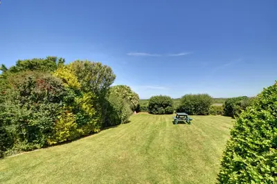 a park with a bench in the middle of a field at 3 Bed in Padstow oc-p00043 in St Merryn