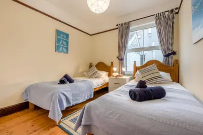 a bedroom with two beds and a window at 3 Bed in Padstow oc-p00043 in St Merryn
