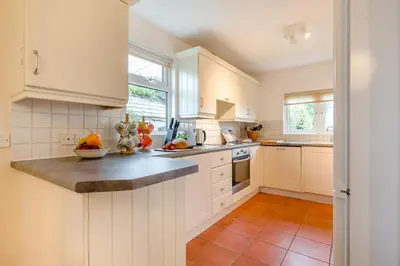 a kitchen with white cabinets and a counter top at 3 Bed in Padstow oc-p00043 in St Merryn
