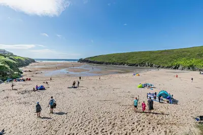 a group of people standing on a beach at 3 Bed in Padstow oc-p00131 in St Merryn