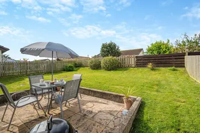 a table and chairs with an umbrella in a yard at 3 Bed in Padstow oc-p00131 in St Merryn
