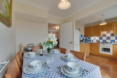 a kitchen with a table with plates and flowers on it at 3 Bed in Wadebridge oc-p00093 in Wadebridge