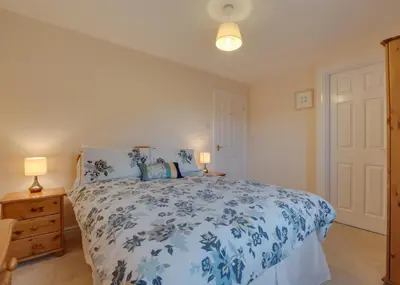 a bedroom with a blue and white bed with two lamps at 3 Bed in Wadebridge oc-p00093 in Wadebridge