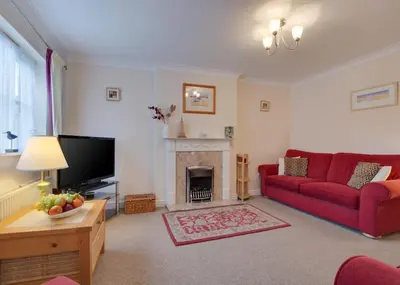 a living room with a red couch and a fireplace at 3 Bed in Wadebridge oc-p00093 in Wadebridge