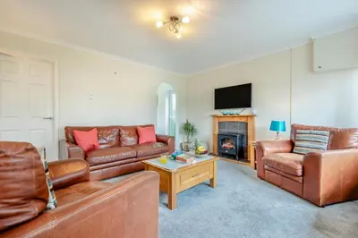 a living room with leather furniture and a fireplace at 3 Bed in St. Merryn oc-p00114 in St Merryn