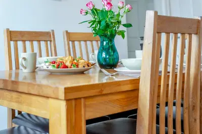 a table with a bowl of food and a vase of flowers at 3 Bed in St. Merryn oc-p00114 in St Merryn