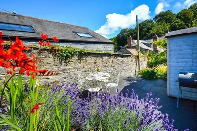 a garden with a table and purple flowers at 2 Bed in Padstow oc-p00082 in Padstow