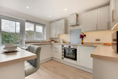 a kitchen with white cabinets and a large window at 4 Bed in Padstow oc-p00184 in Padstow