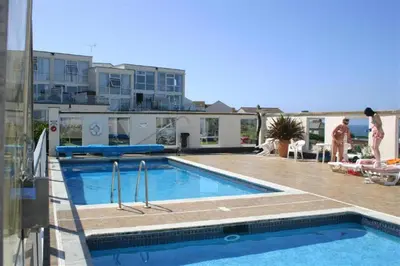 a swimming pool in front of a building at 2 Bed in Newquay oc-p00214 in Newquay
