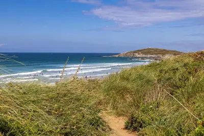 a sandy beach with people walking on the beach at 2 Bed in Newquay oc-p00214 in Newquay