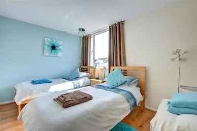 two beds in a room with blue walls at 2 Bed in Newquay oc-p00214 in Newquay