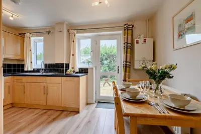 a kitchen with a wooden table and a dining room at 2 Bed in Padstow oc-p00183 in Padstow