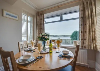 a dining room with a table and a large window at 2 Bed in Padstow oc-p00134 in Padstow
