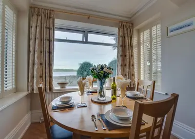 a dining room with a table and a large window at 2 Bed in Padstow oc-p00134 in Padstow
