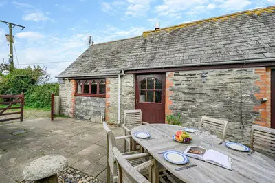 a wooden table in front of a stone cottage at 2 Bed in Padstow oc-p00249 in Padstow