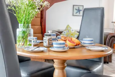a wooden table with a plate of food on it at 2 Bed in Padstow oc-p00249 in Padstow