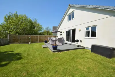 a backyard with a white house and a fence at 3 Bed in St. Merryn oc-p00251 in St Merryn
