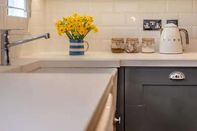 a kitchen counter with a sink and a vase of flowers at 3 Bed in Padstow oc-p00165 in Padstow