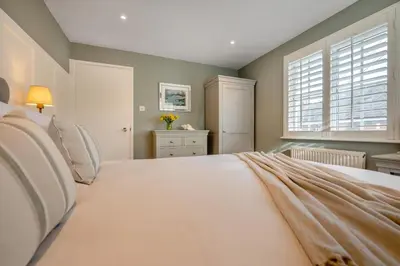 a bedroom with a large white bed with a window at 3 Bed in Padstow oc-p00165 in Padstow