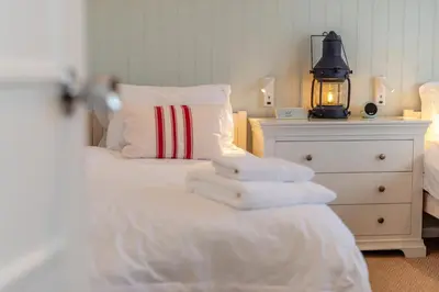 a bedroom with a white bed with towels on it at 3 Bed in Padstow oc-p00165 in Padstow