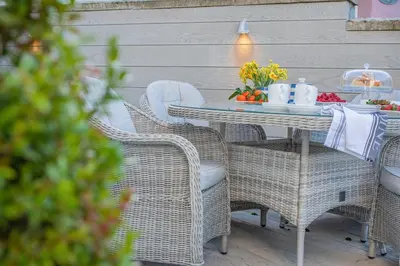 a table with wicker chairs and a table with food on it at 3 Bed in Padstow oc-p00165 in Padstow