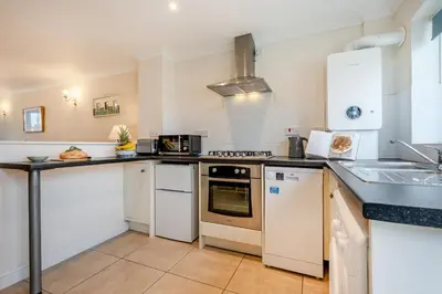 a kitchen with white cabinets and a stove top oven at 2 Bed in Padstow oc-p00254 in Padstow