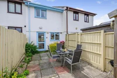 a patio with a table and chairs and a fence at 2 Bed in Padstow oc-p00254 in Padstow